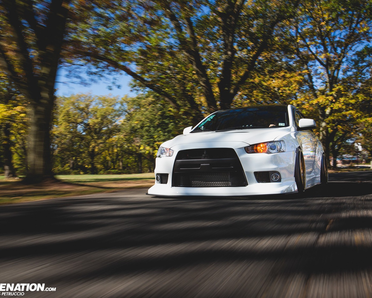 Белый Mitsubishi Lancer Evo X на дороге