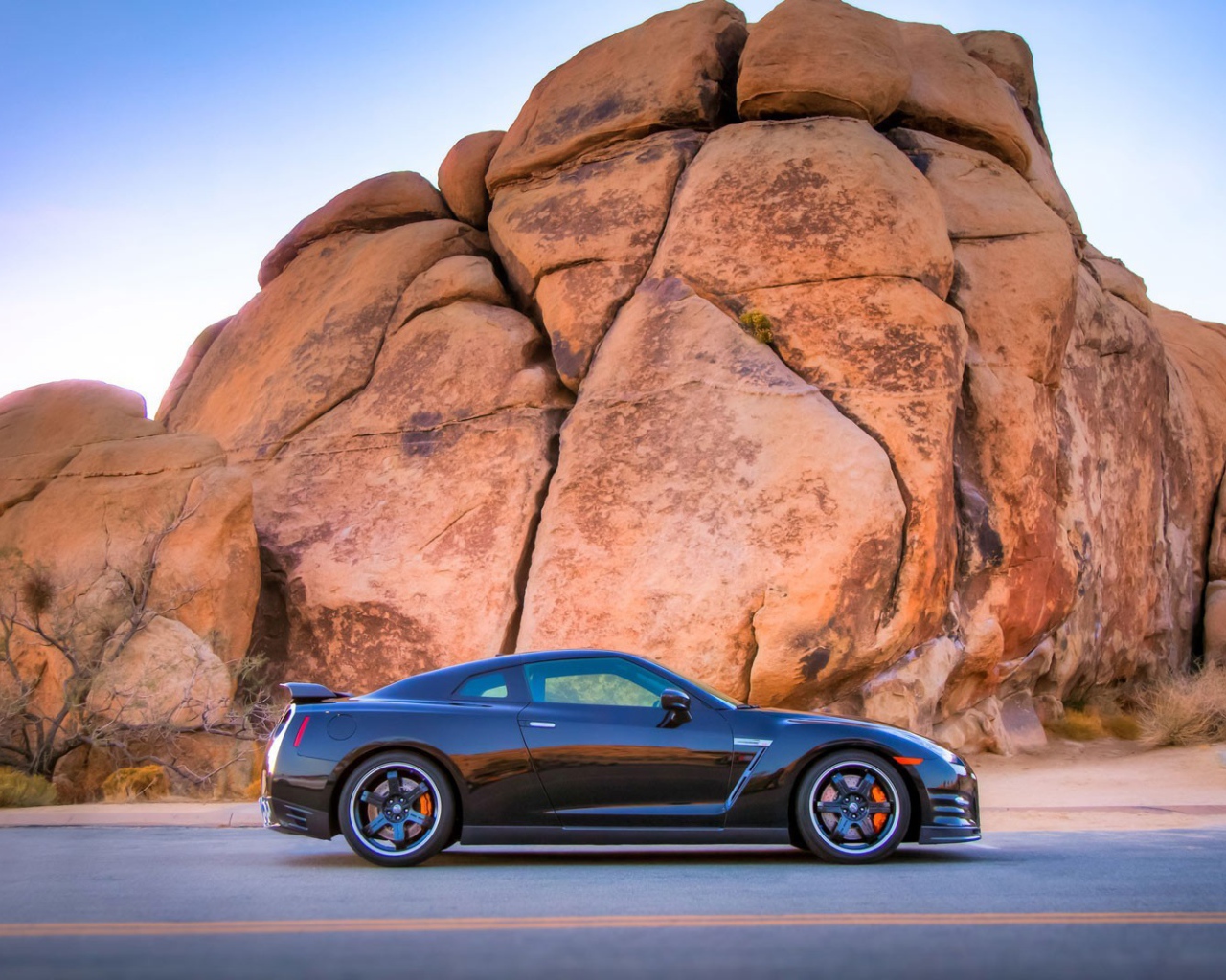 Черный Nissan GT-R у подножия скалы