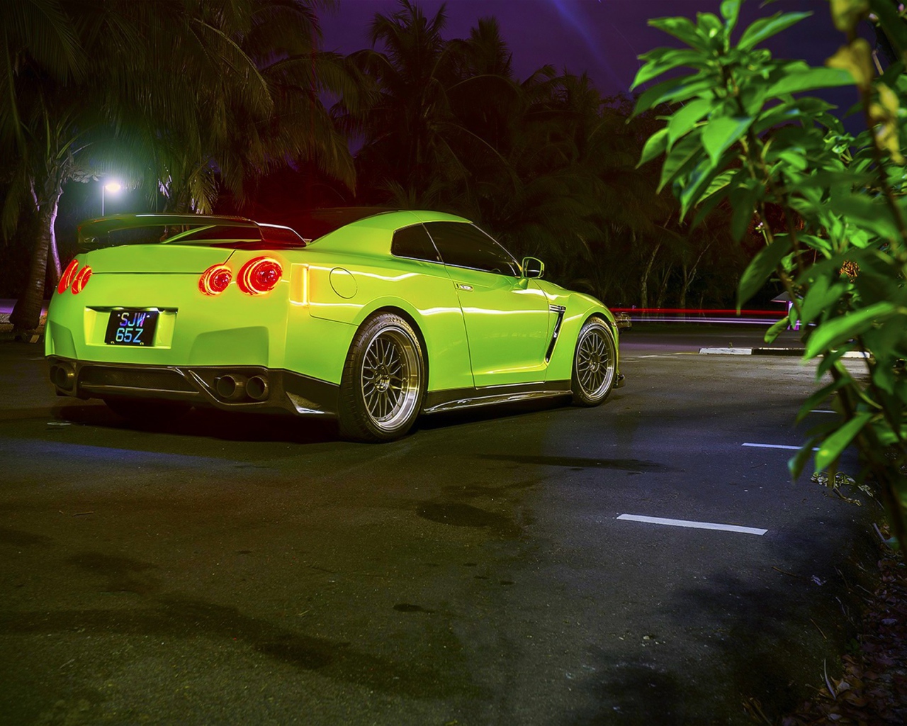 Зеленый спортивный Nissan на ночной улице города