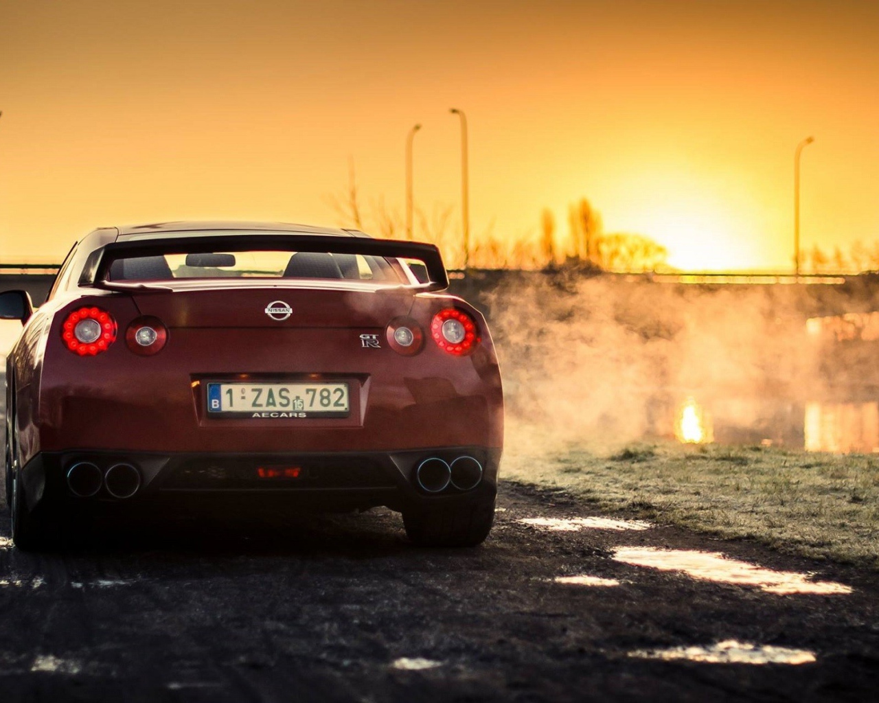 Красный Nissan у реки на рассвете