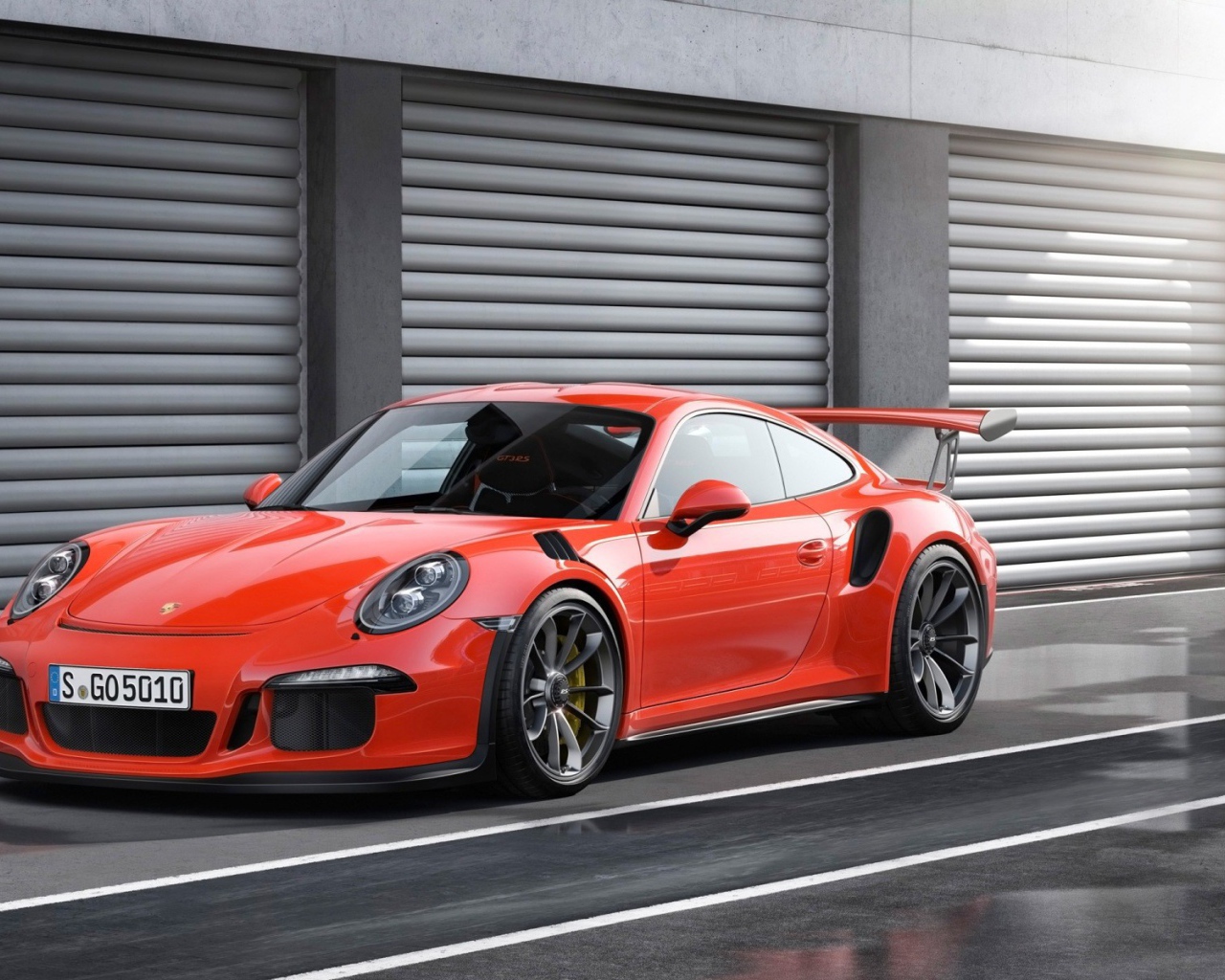 Red Porsche 911 GT3 RS at the gate of garages