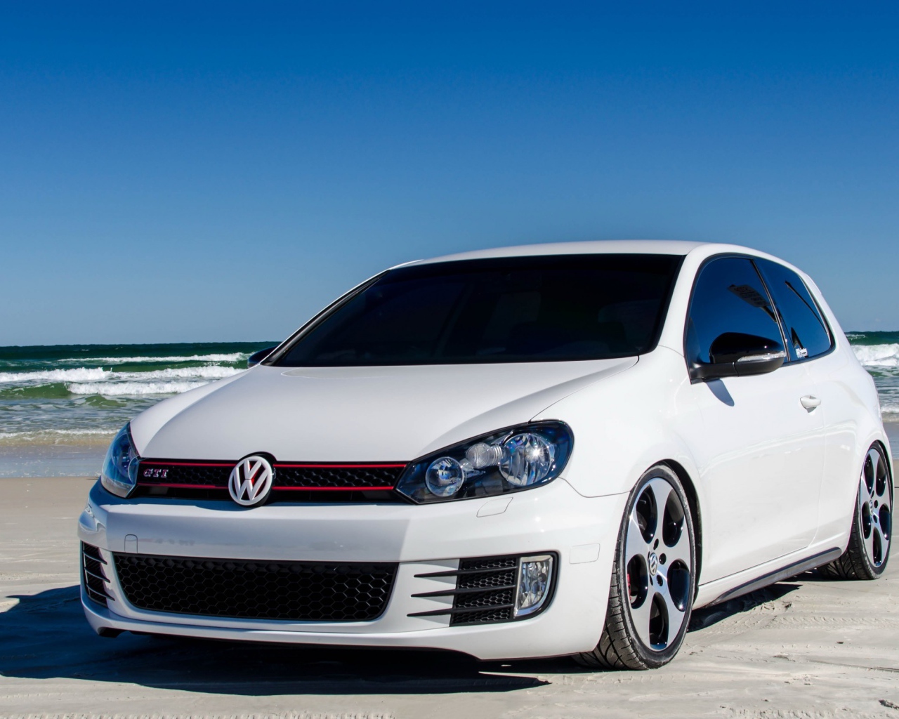 Белый Volkswagen Golf Mk6 GTI на берегу моря