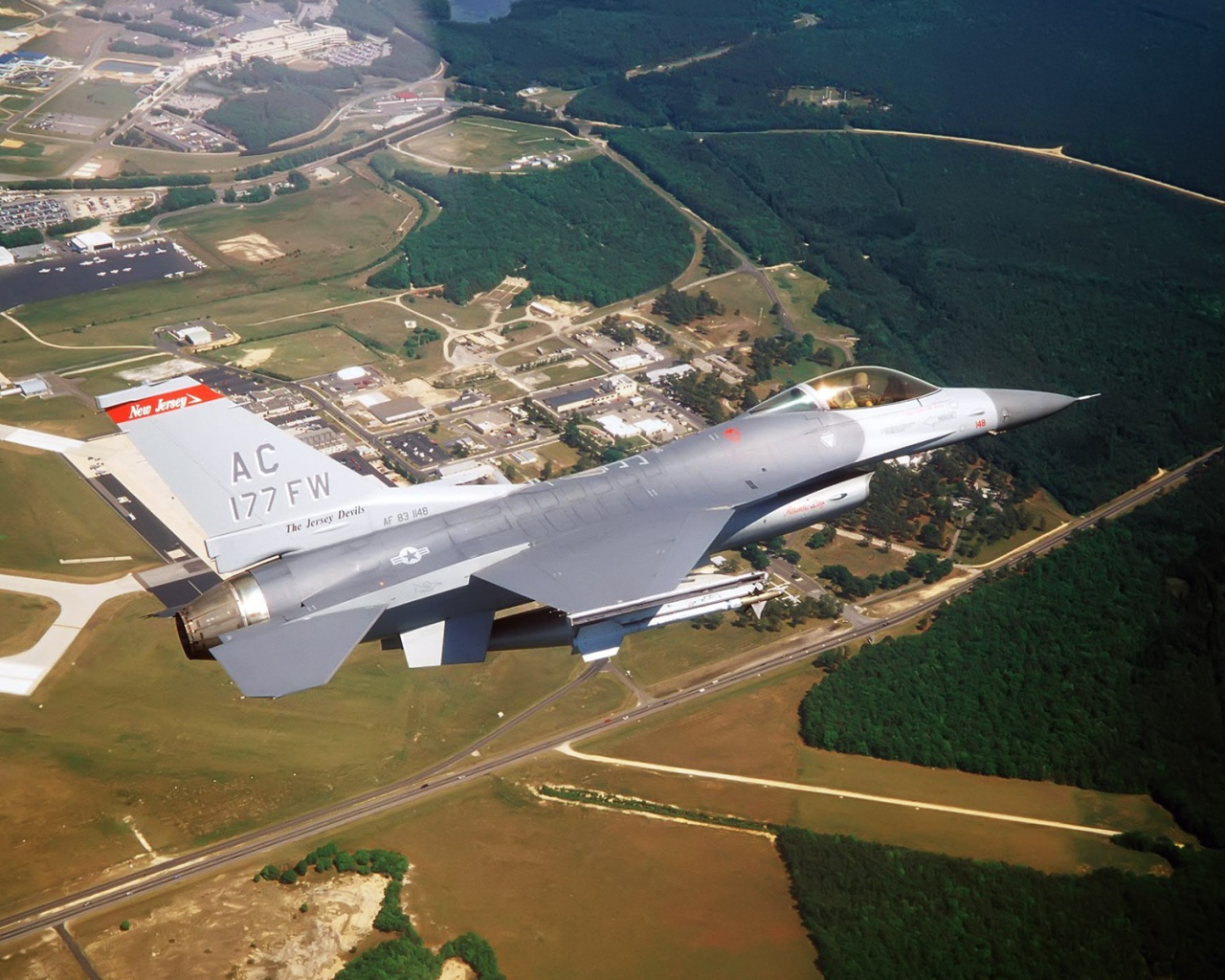 Истребитель F-16 выполняет маневр над землей