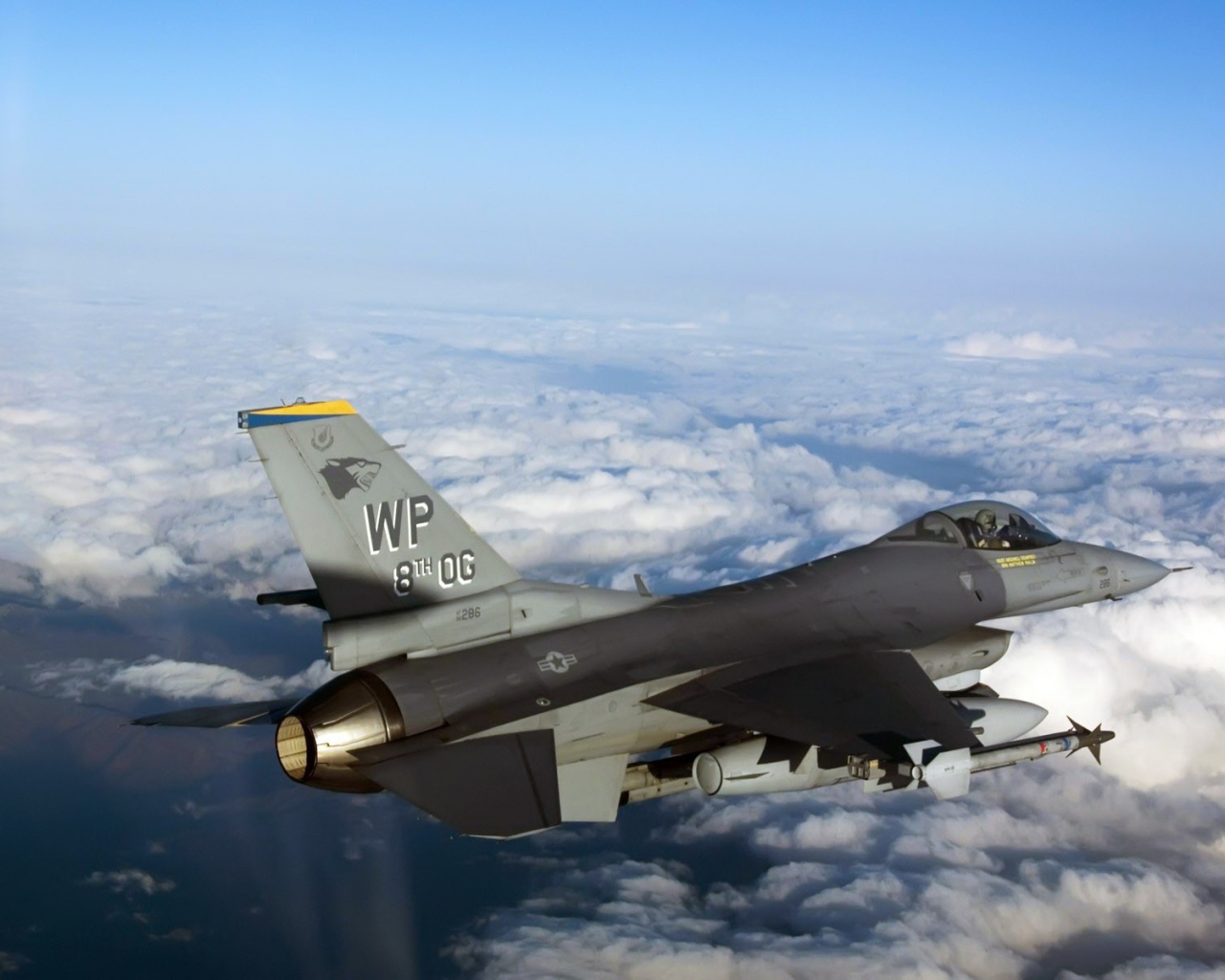 Военный самолет F-16 над облаками