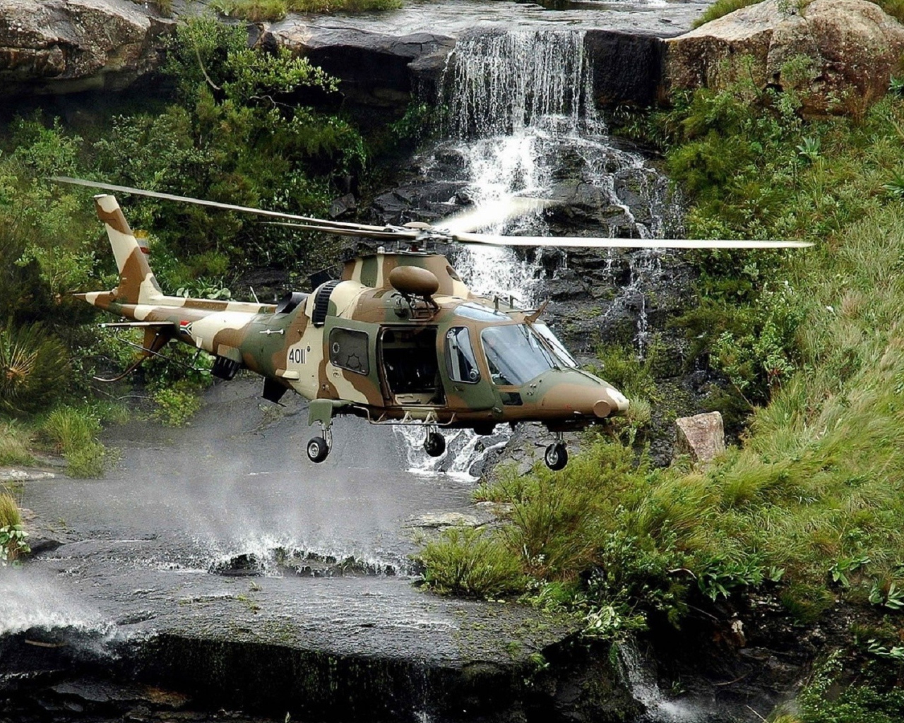Военный вертолет над водопадом