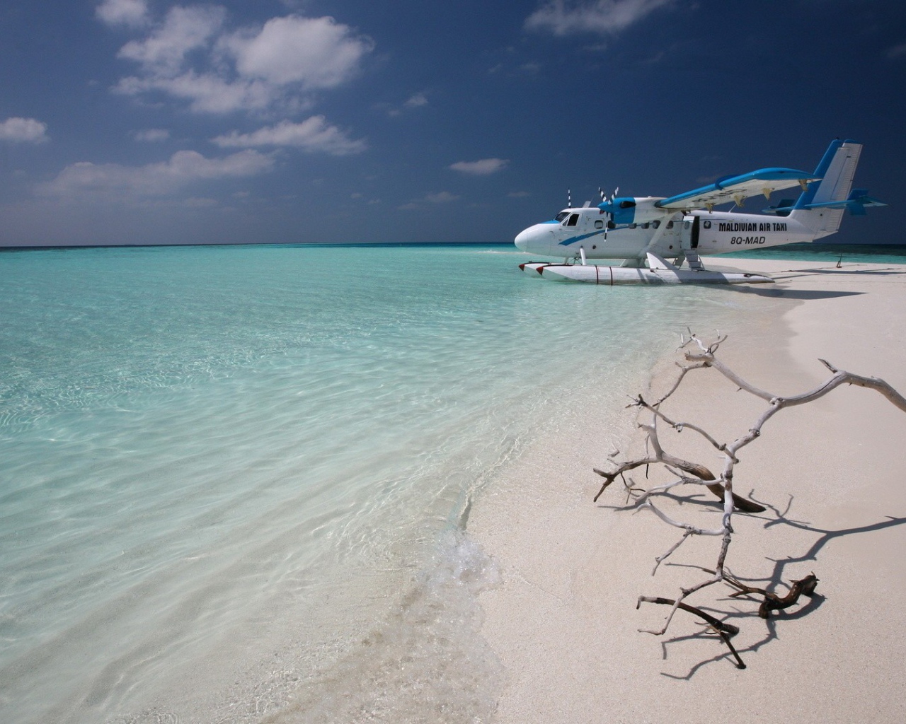Самолет сел на воду у белого пляжа