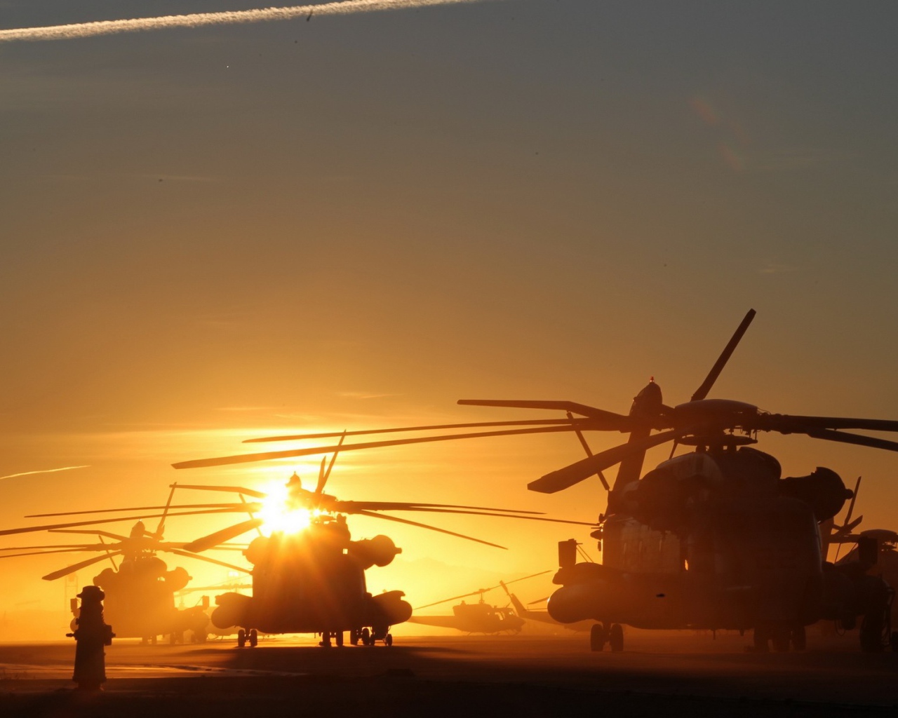 Несколько вертолетов на фоне заката