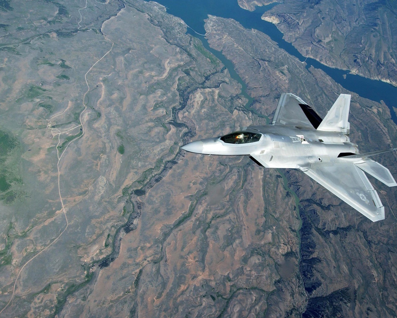 Самолет F-22 Raptor над поверхностью земли