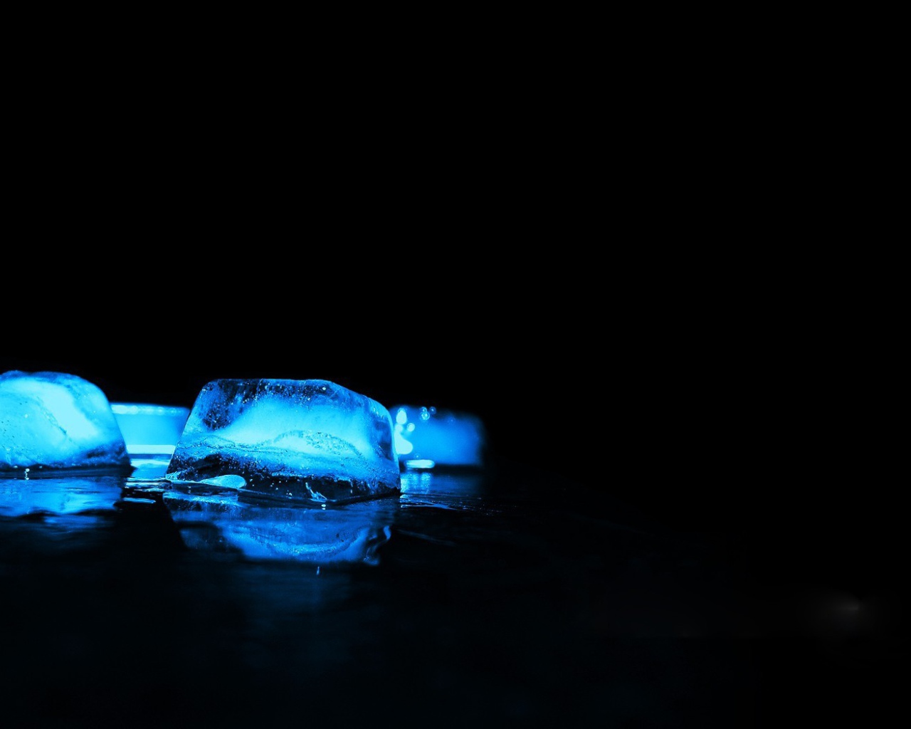 Голубые кубики льда на черном фоне