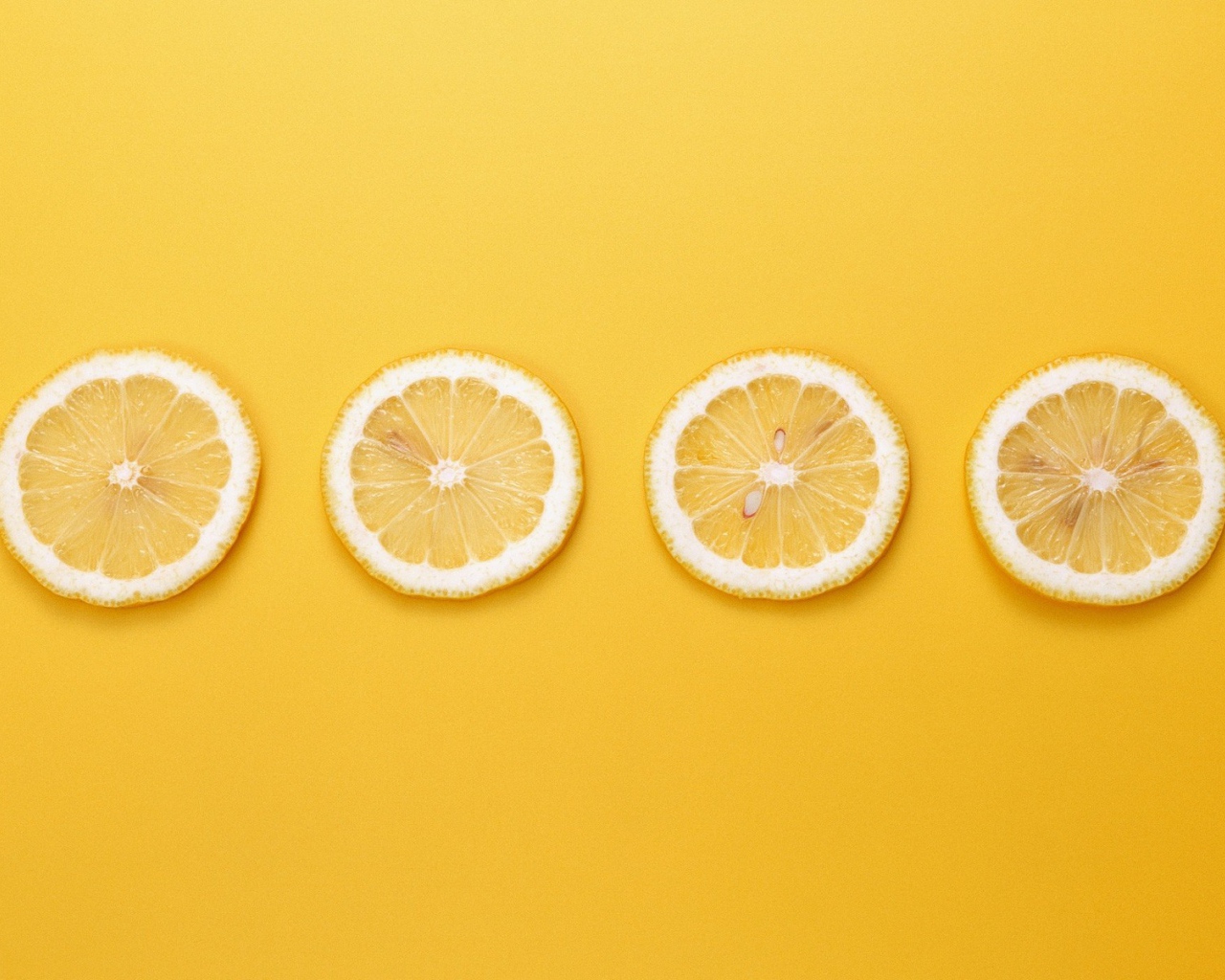 Кружки лимона, желтый фон