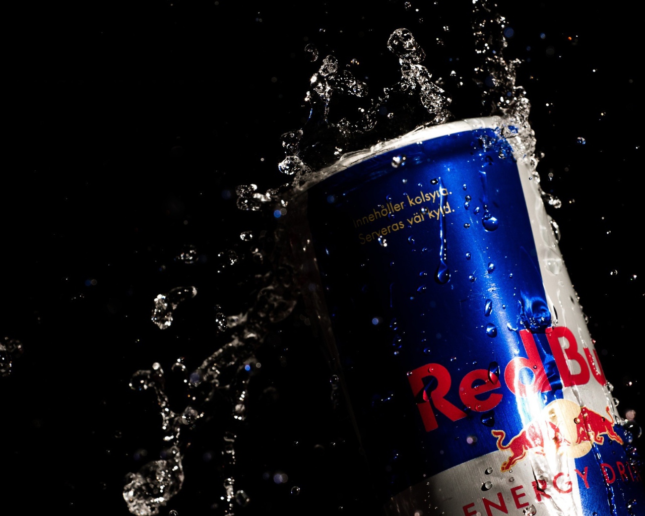 Напиток Red Bull в каплях воды