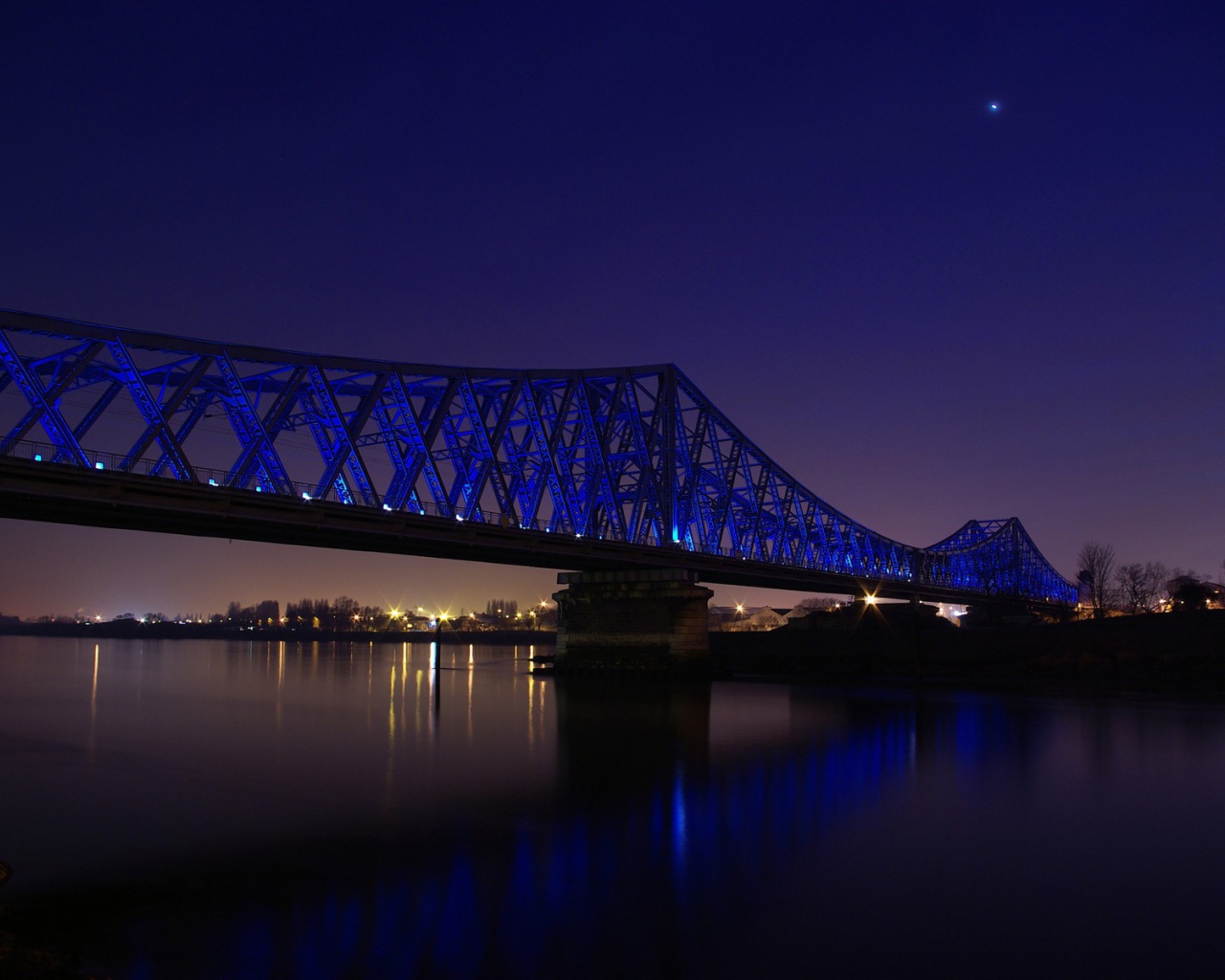 Синяя ночная подсветка моста через реку