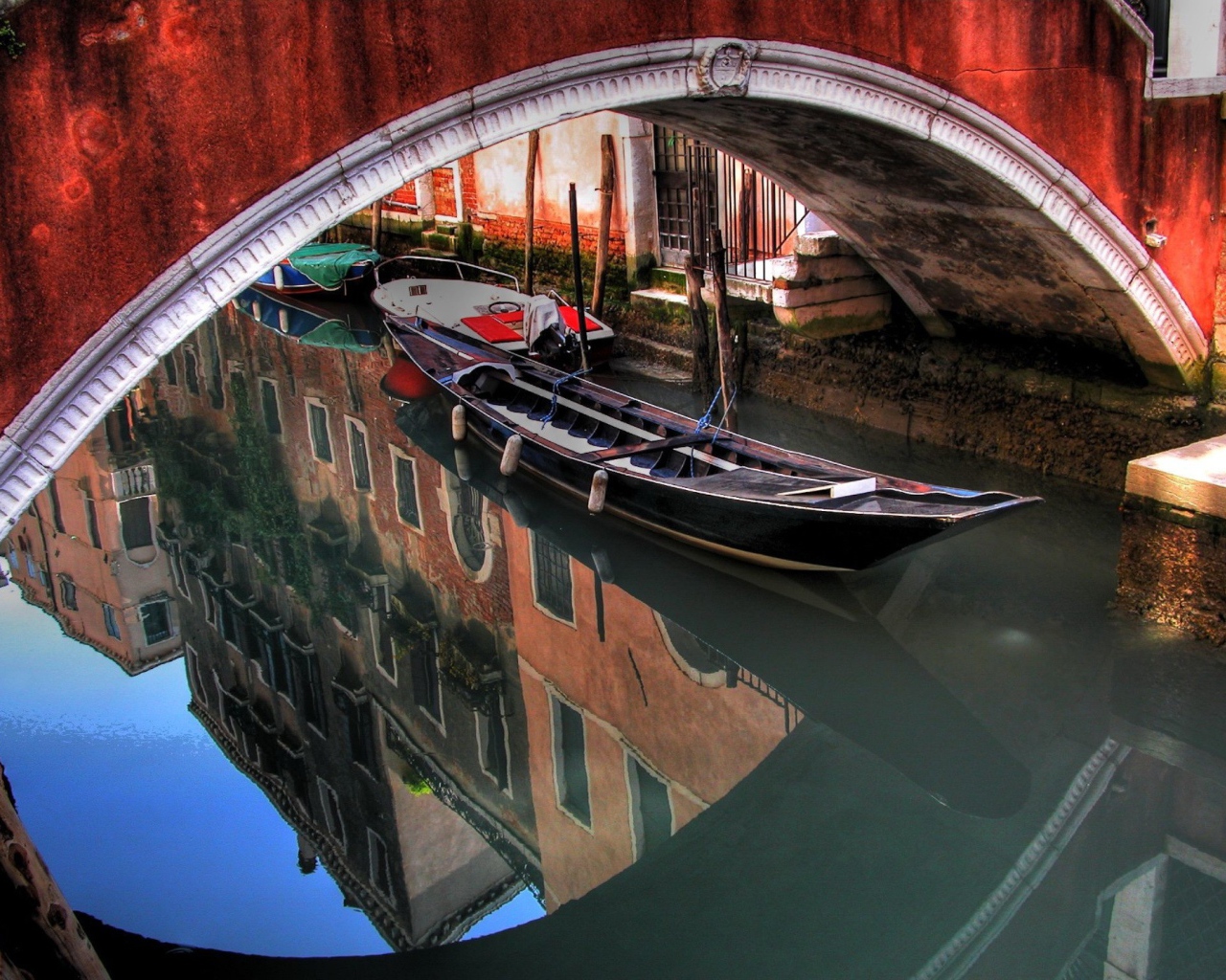 Лодка под красным мостом в Венеции