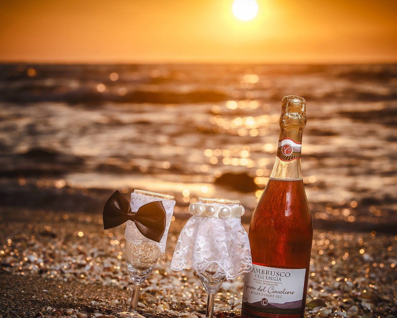 Бутылка вина и два бокала на пляже