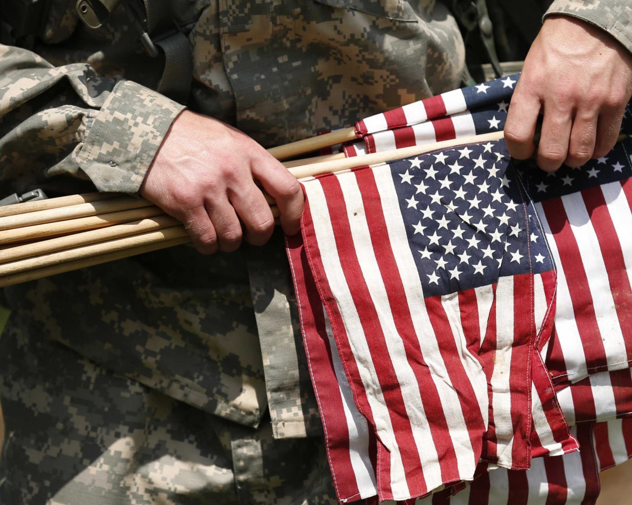 Солдат держит в руке флаги США