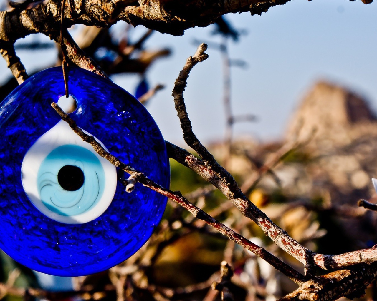 Оберег из синего стекла на дереве