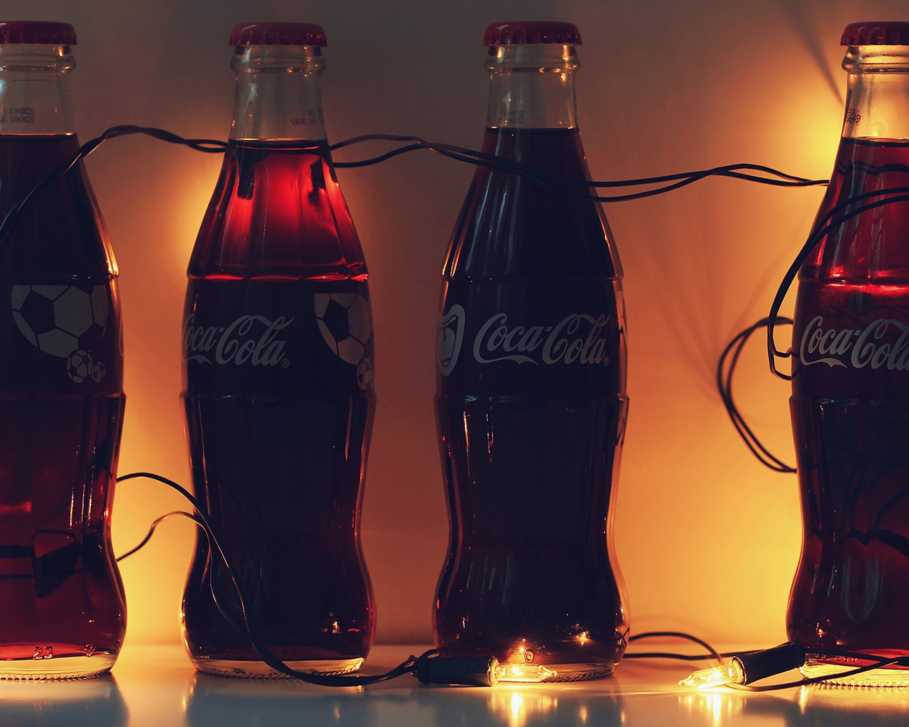Бутылки Кока-Колы связанные новогодней гирляндой