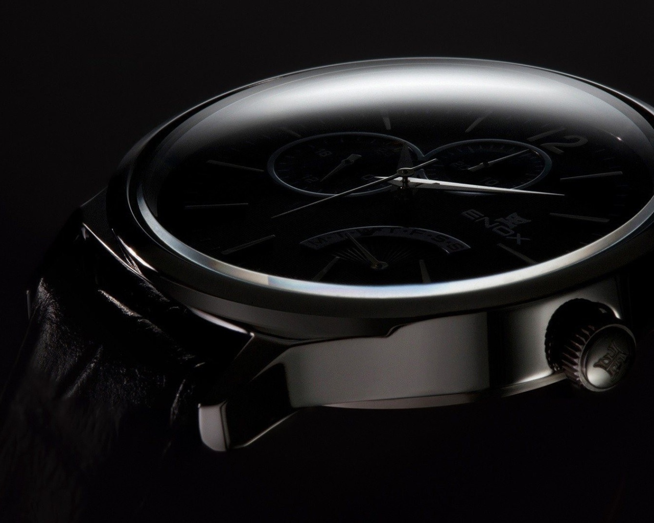 Дорогие черные часы на черном фоне