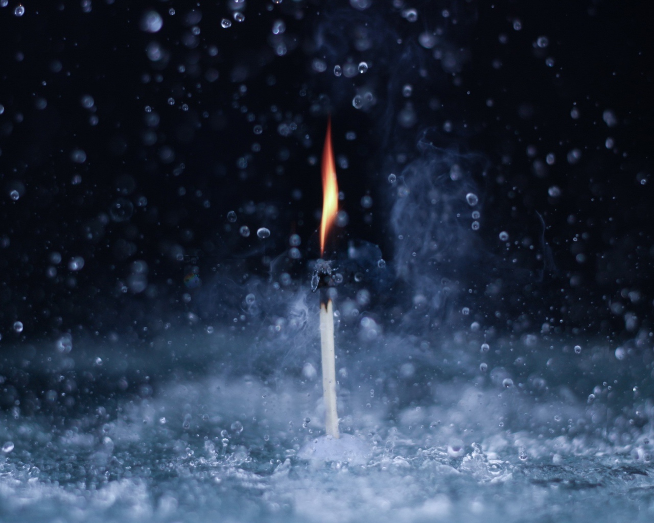 Пламя спички среди капель воды