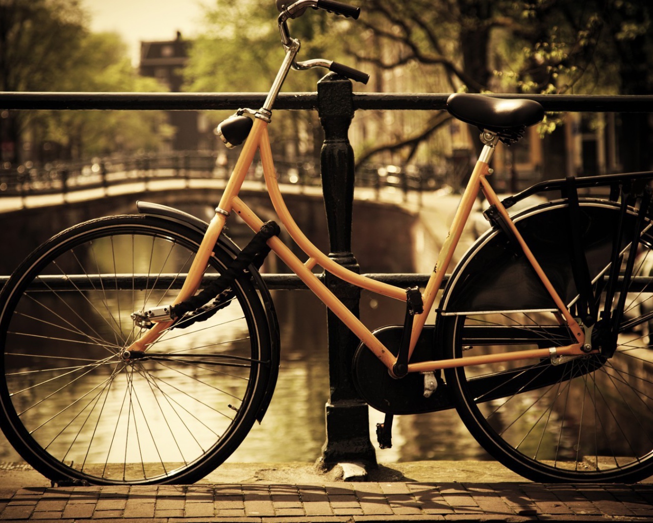 Оранжевый велосипед прислонен к перилам