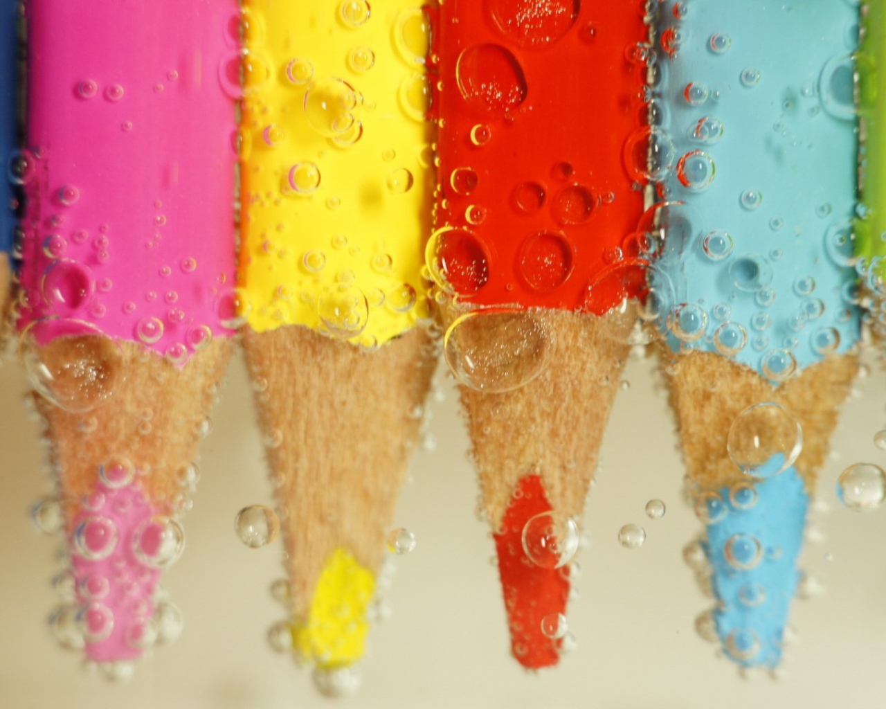 Карандаши в воде среди пузырей воздуха