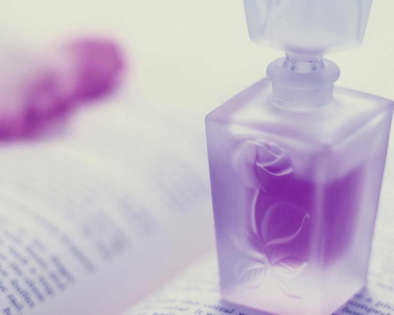 Флакон духов на открытой книге