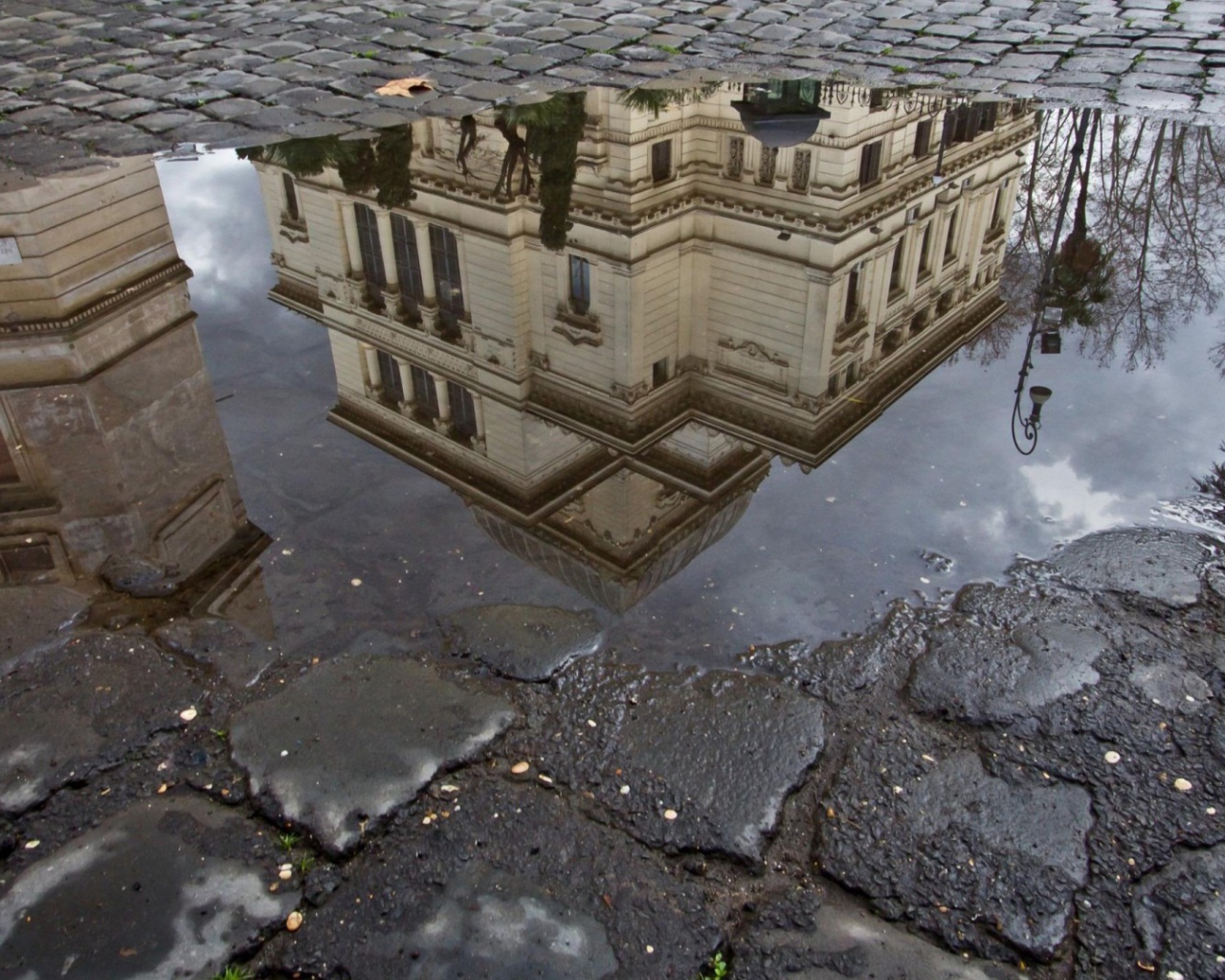 Отражение городского здания в луже