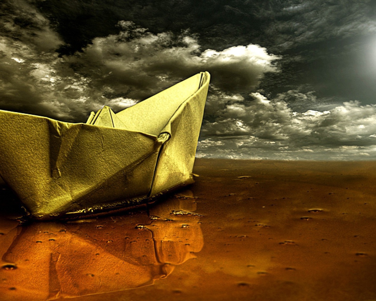 Корабль из бумаги на мокром песке