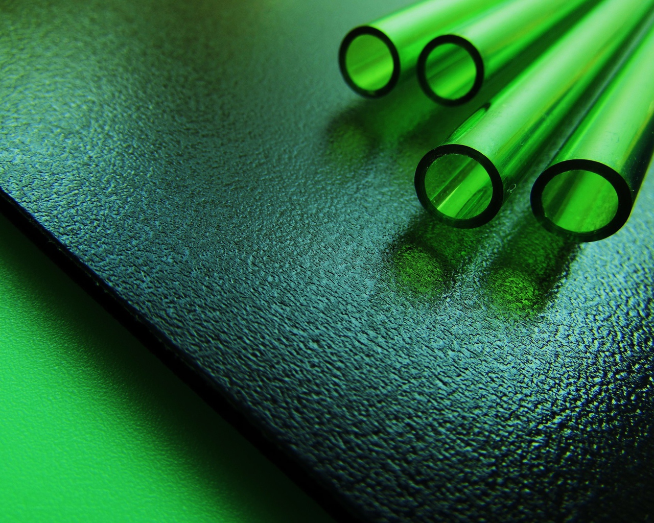 Трубки из зеленого стекла на черной плите