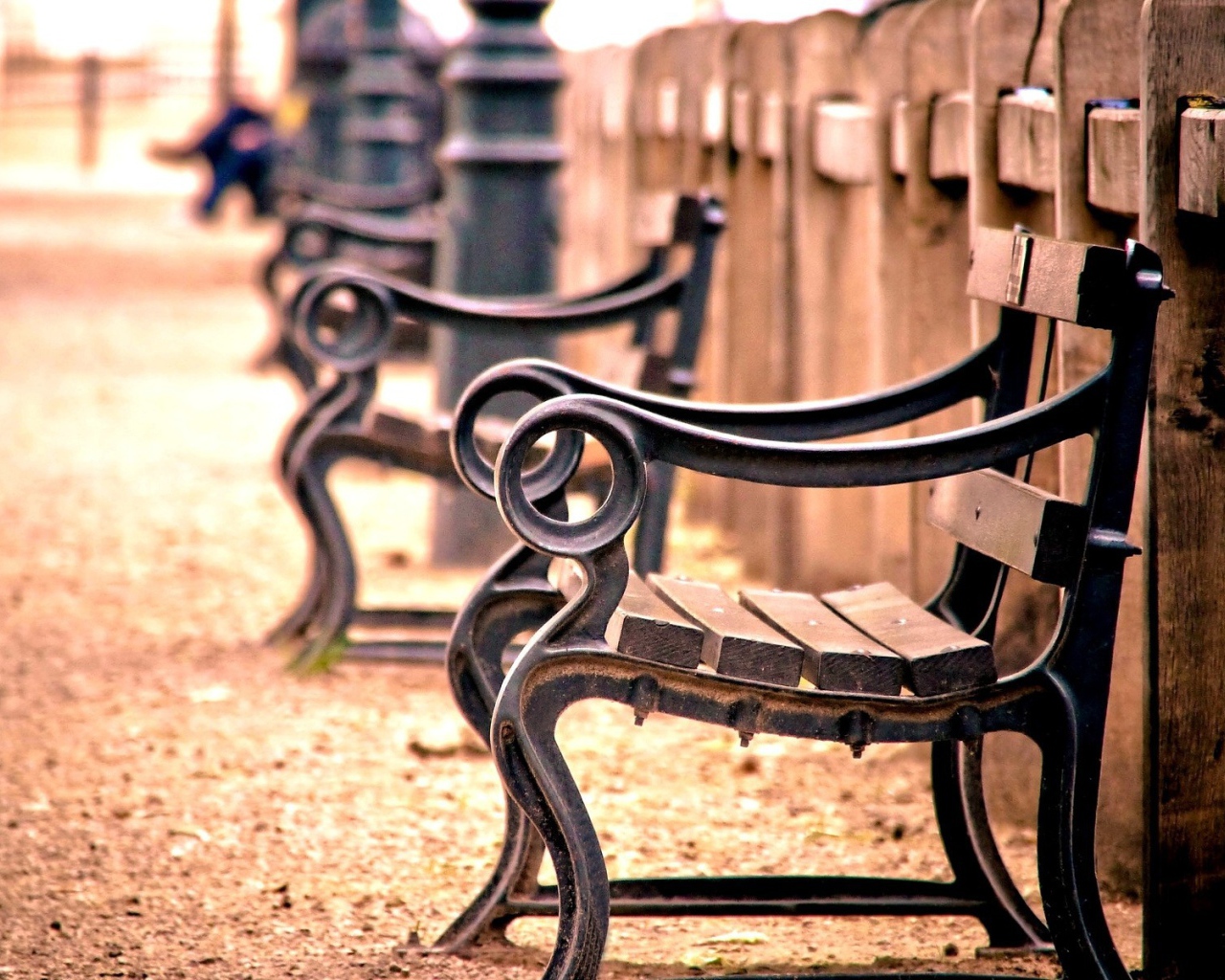 Кованые скамьи у деревянного забора