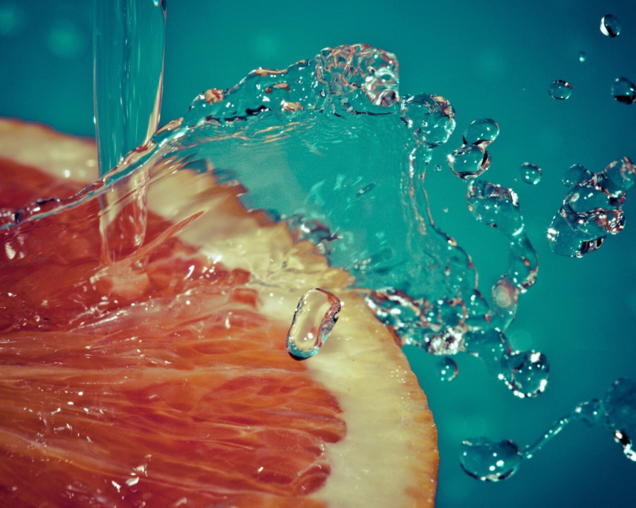 Вода льется на срез грейпфрута