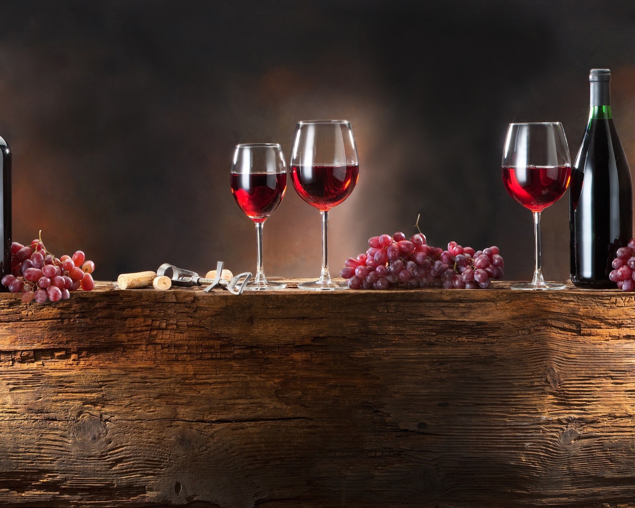 Красное вино и виноград на деревянной подставке