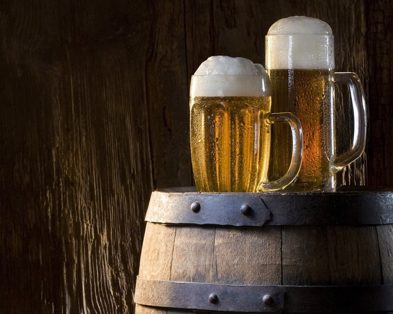 Два бокала холодного пива на бочке