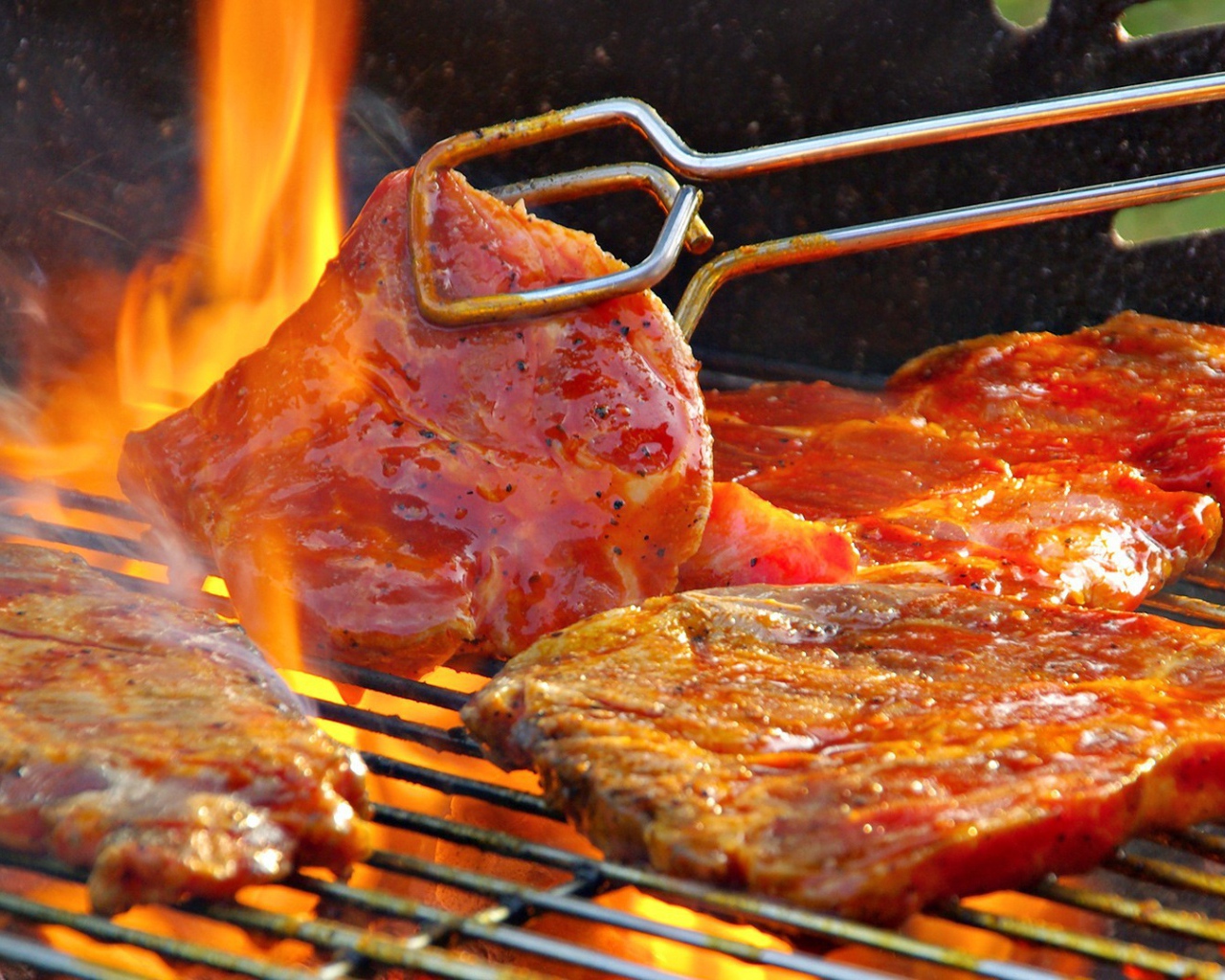 Стейк жарится на огне барбекю