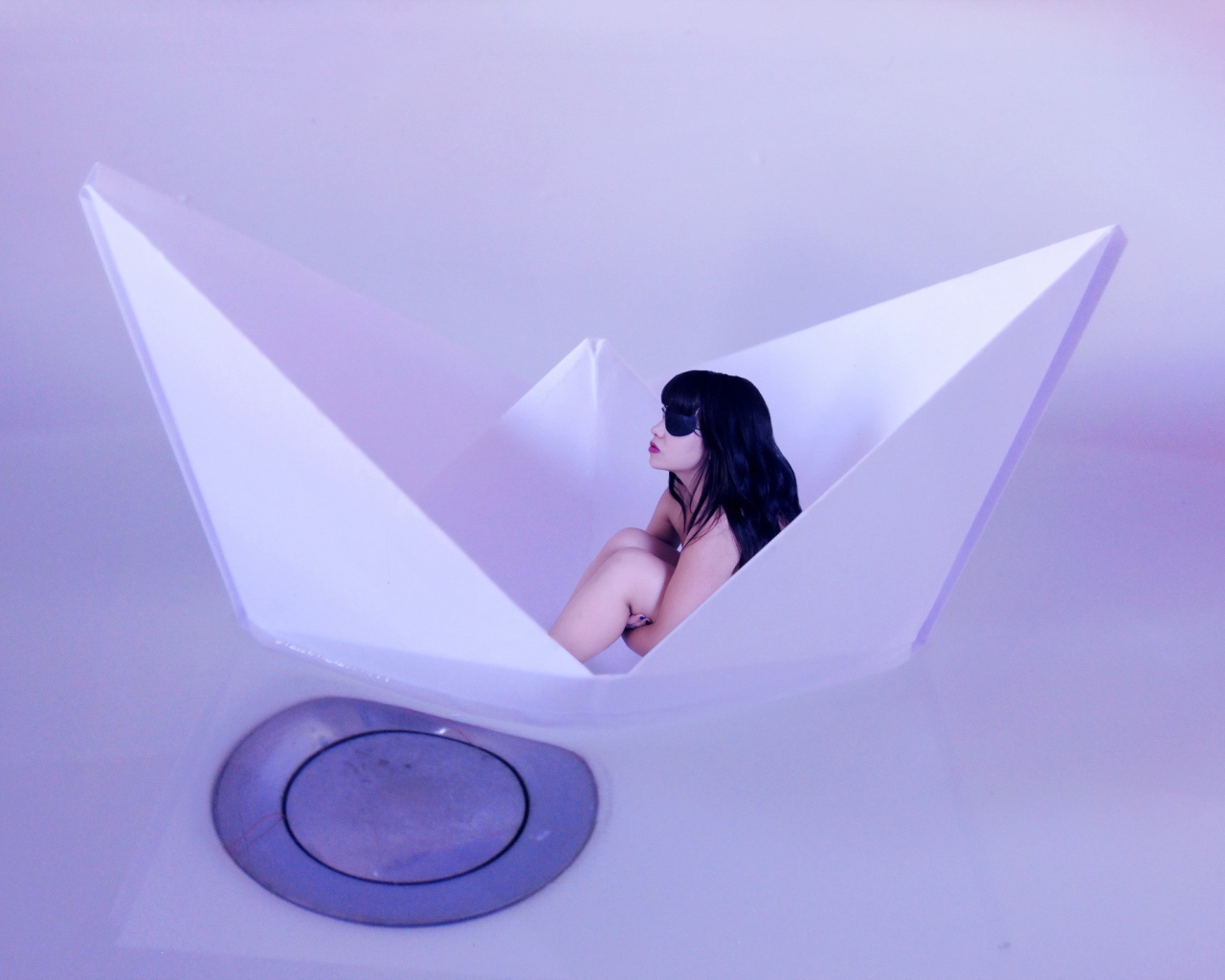 Девушка сидит в бумажном кораблике