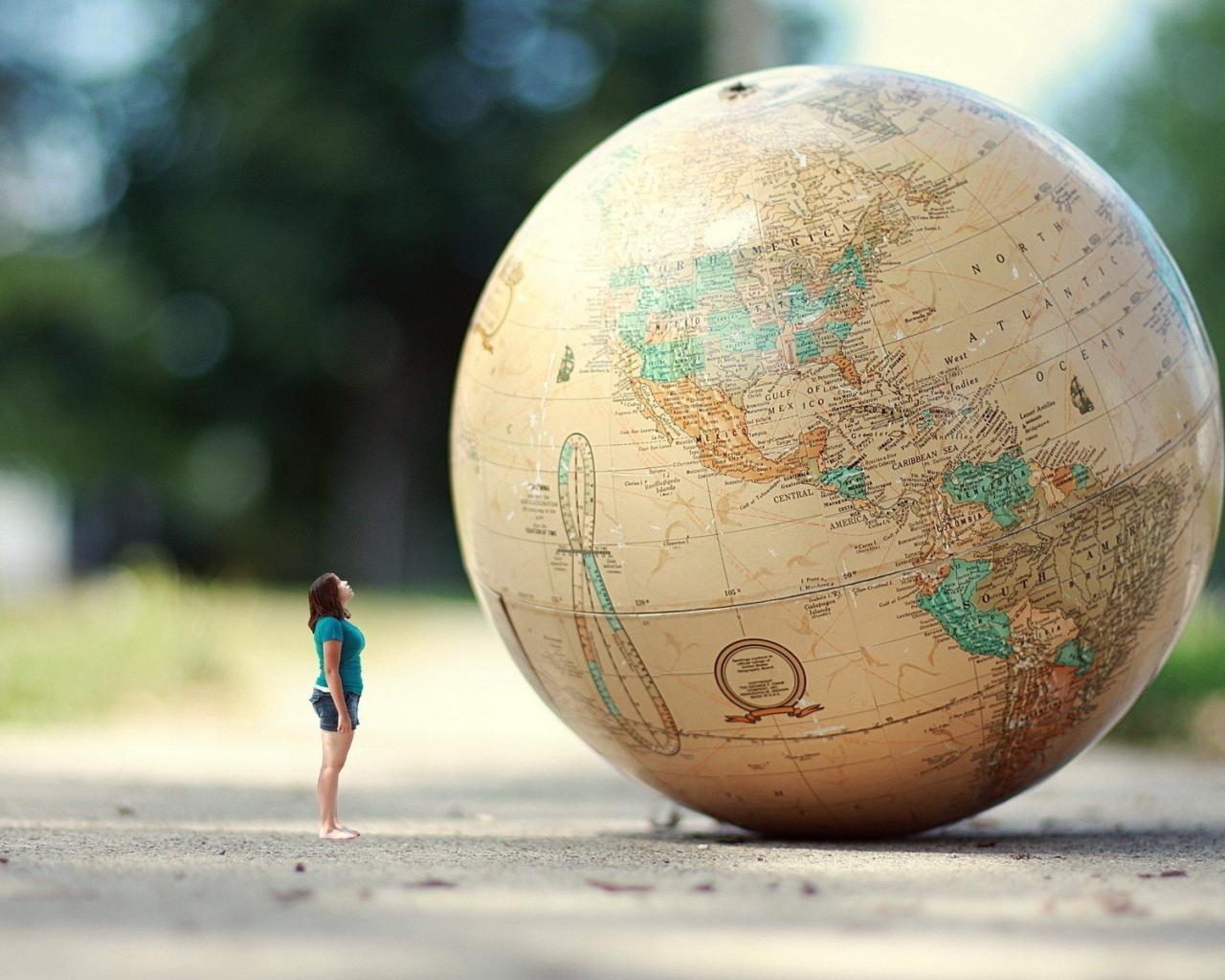Девушка стоит перед огромным глобусом