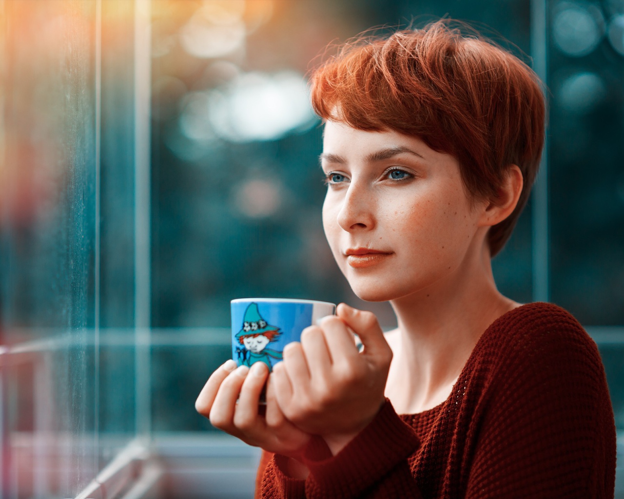 Девушка с короткими волосами пьет кофе