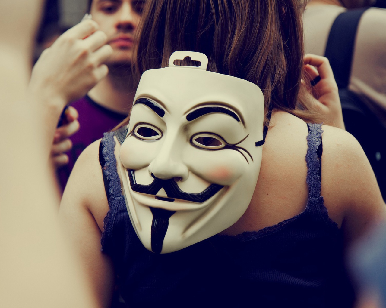 Маска Анонимуса на затылке девушки