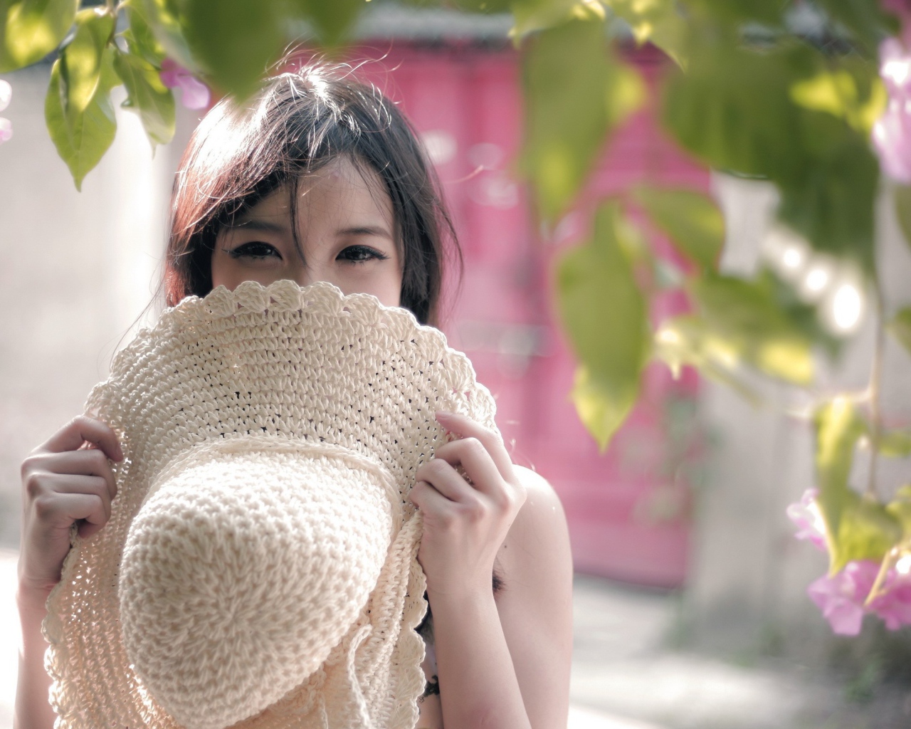 Азиатская девушка прикрыла лицо шляпой