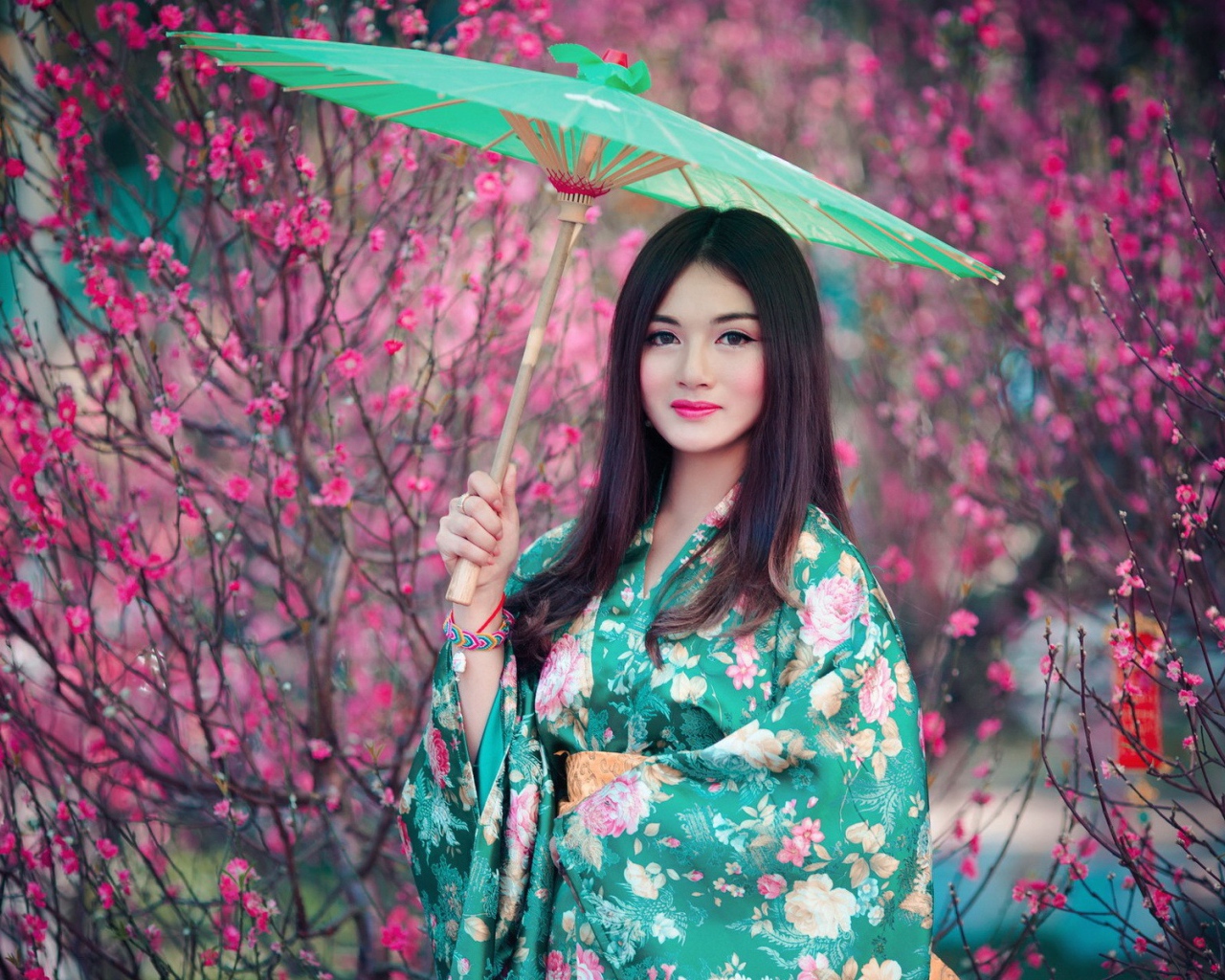 Азиатская девушка в кимоно с зеленым зонтиком
