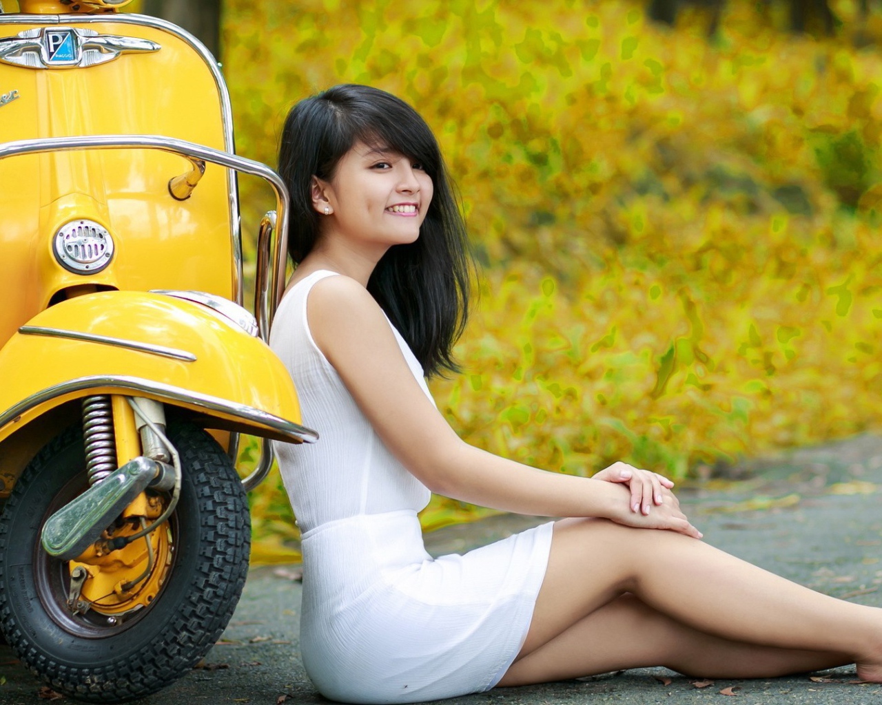 Азиатская девушка у желтого мотороллера