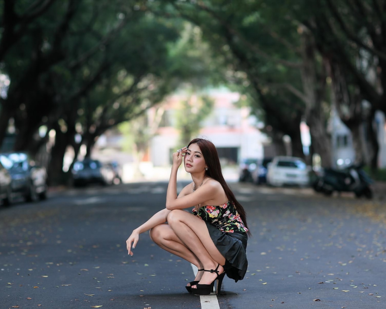 Азиатская девушка сидит на корточках