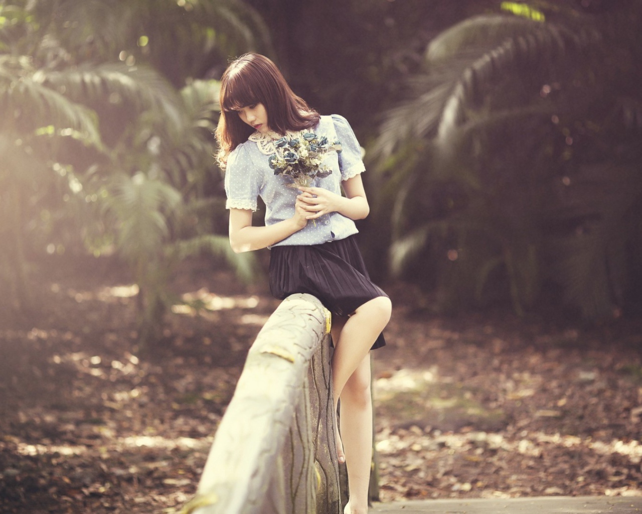 Азиатка с букетом на поручне моста