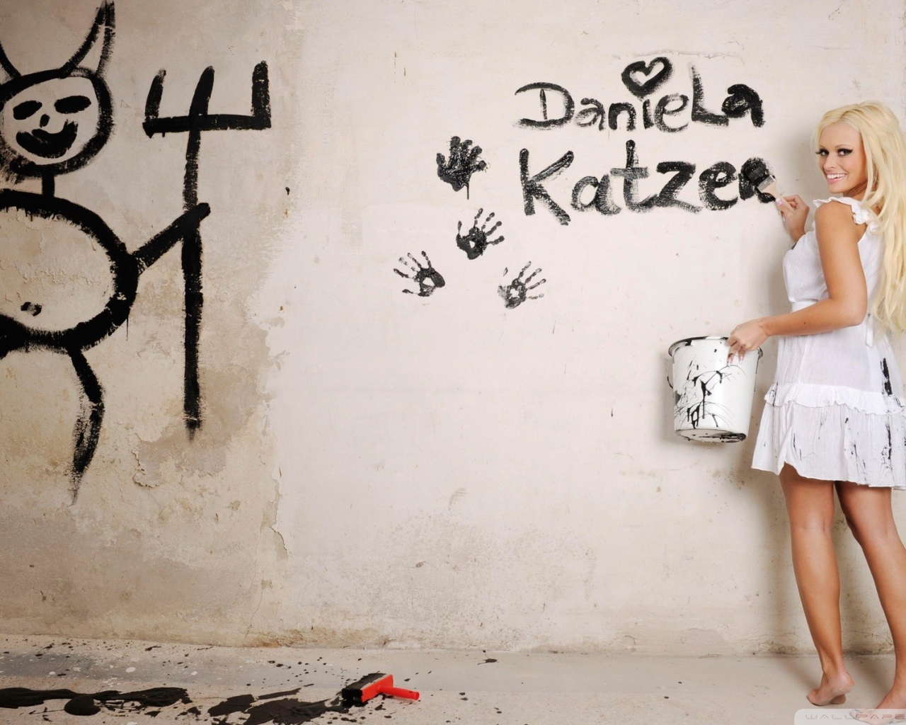 Блондинка рисует на стене