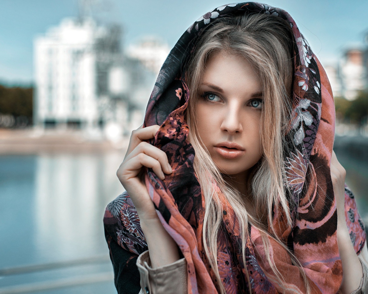 Блондинка в накидке на фоне городского пруда