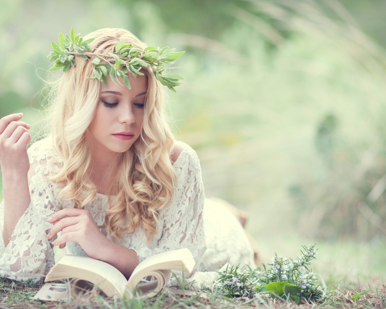 Блондинка в зеленом венке читает книгу