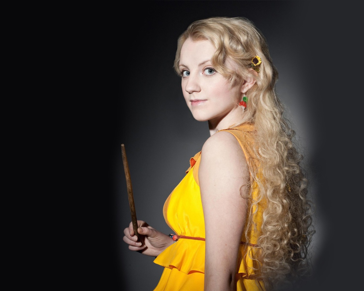 Блондинка в желтом платье на сером фоне