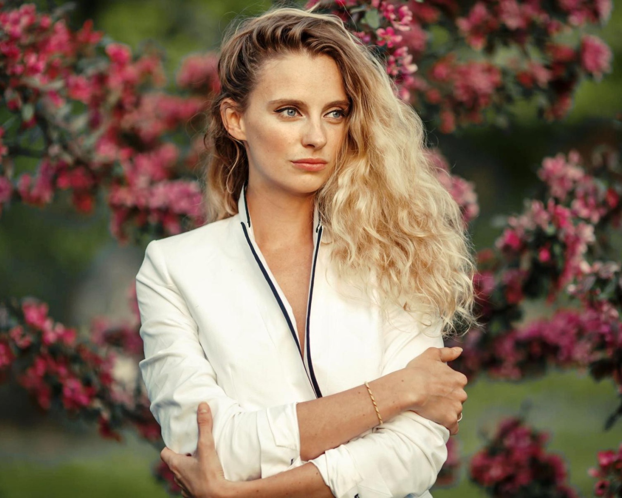 Голубоглазая блондинка на фоне цветущих деревьев