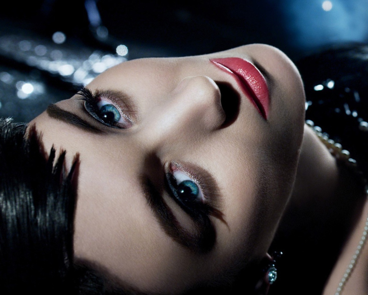 Голубоглазая брюнетка лежит в черном платье