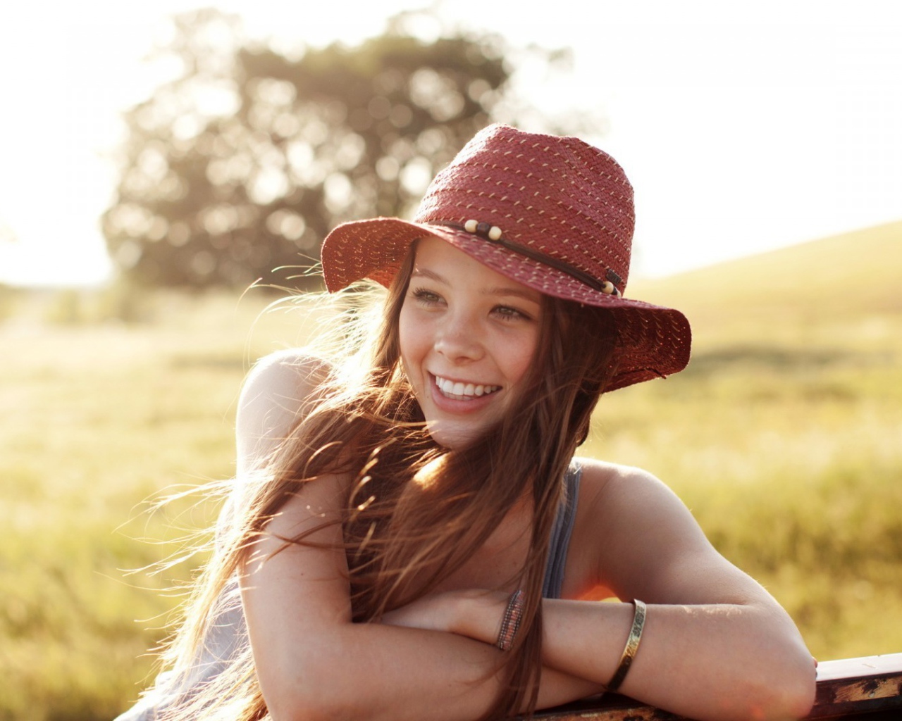 Веселая девушка в легкой красной шляпе